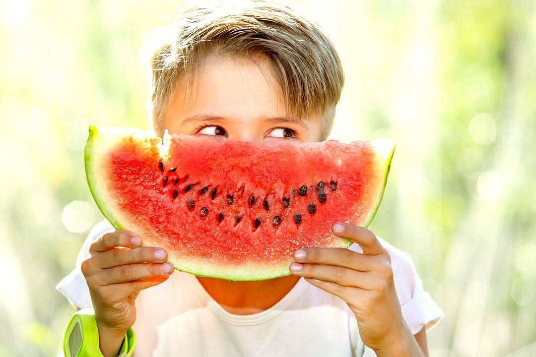 child eats watermelon